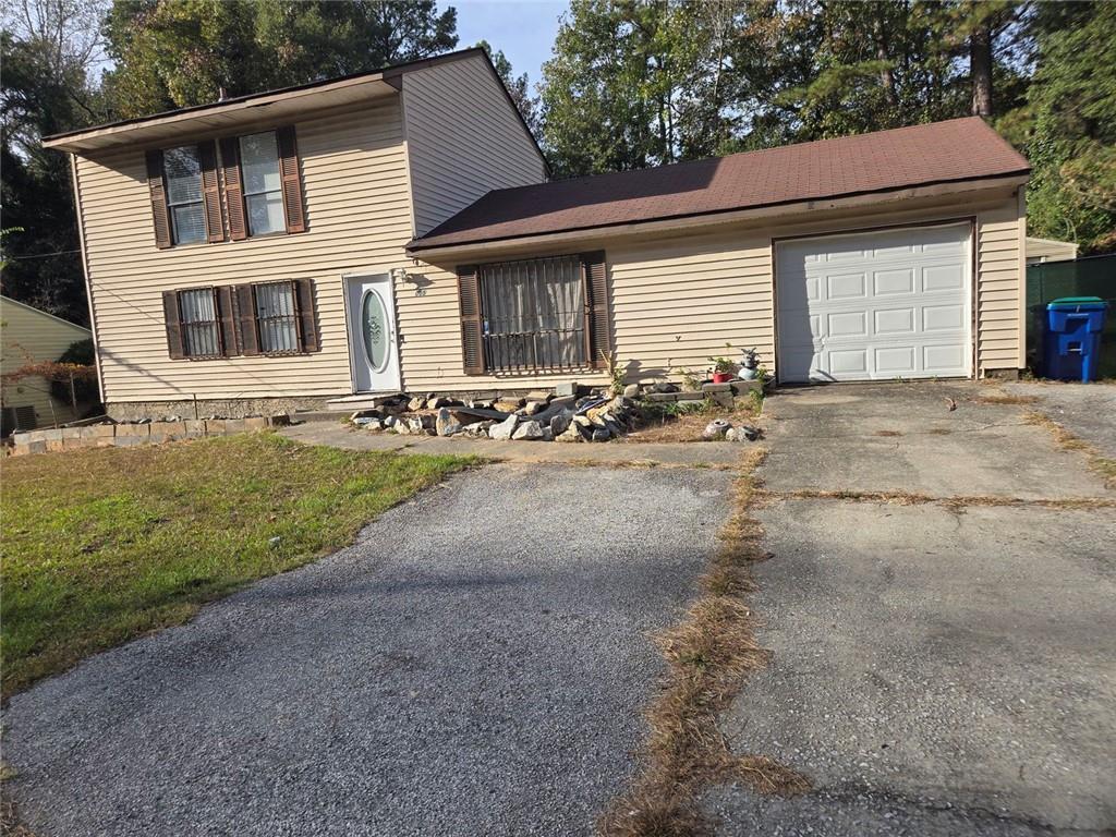 a front view of a house with a garden and parking