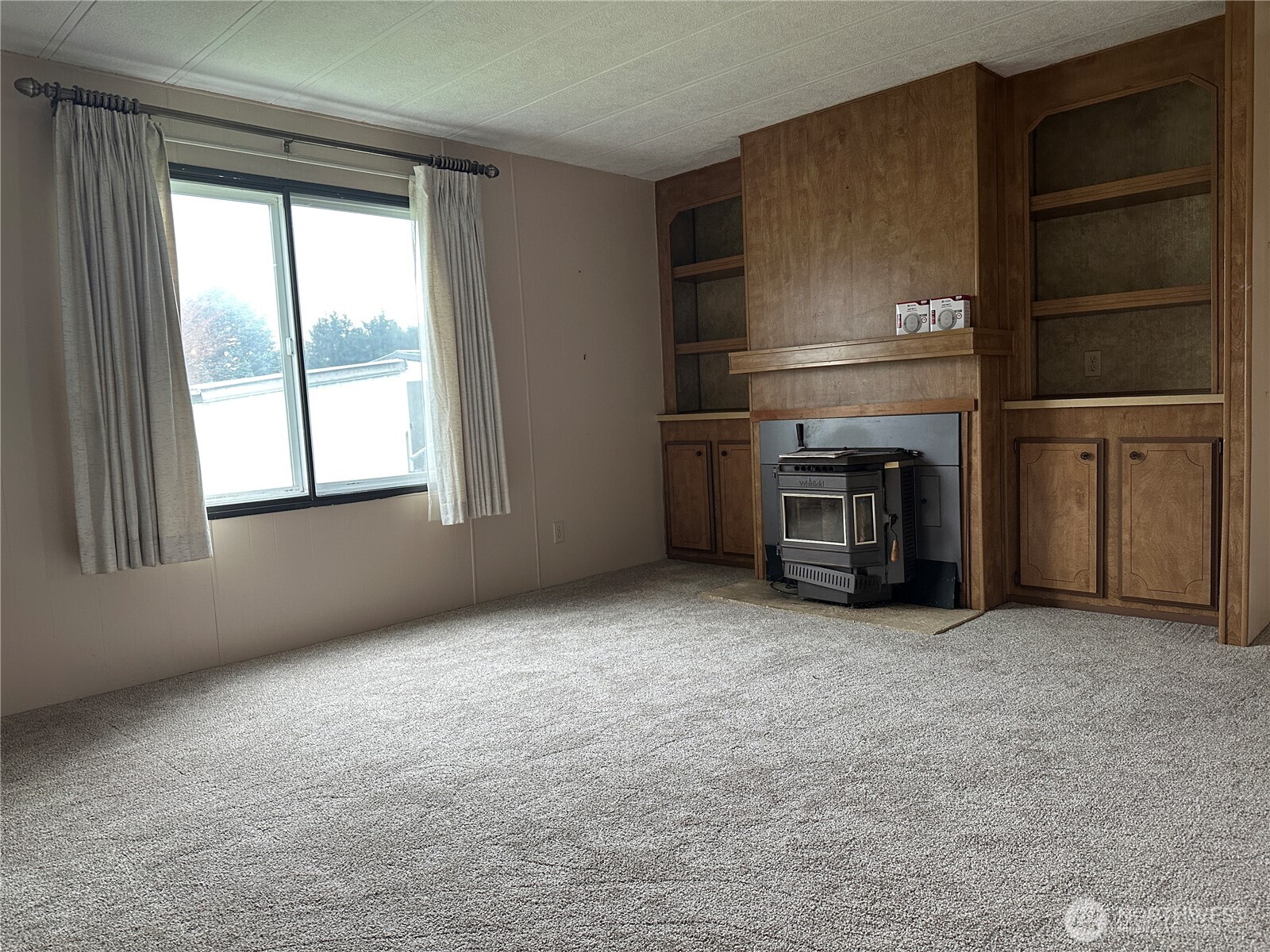 57 Clemons Road, Unit 49 Montesano, WA 98563 - Photo 11 of 23 an empty room with a fireplace cabinet and window