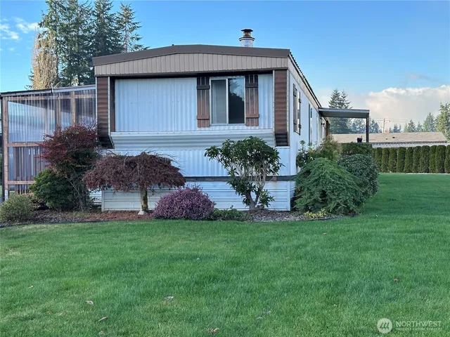 a front view of a house with a yard and plants