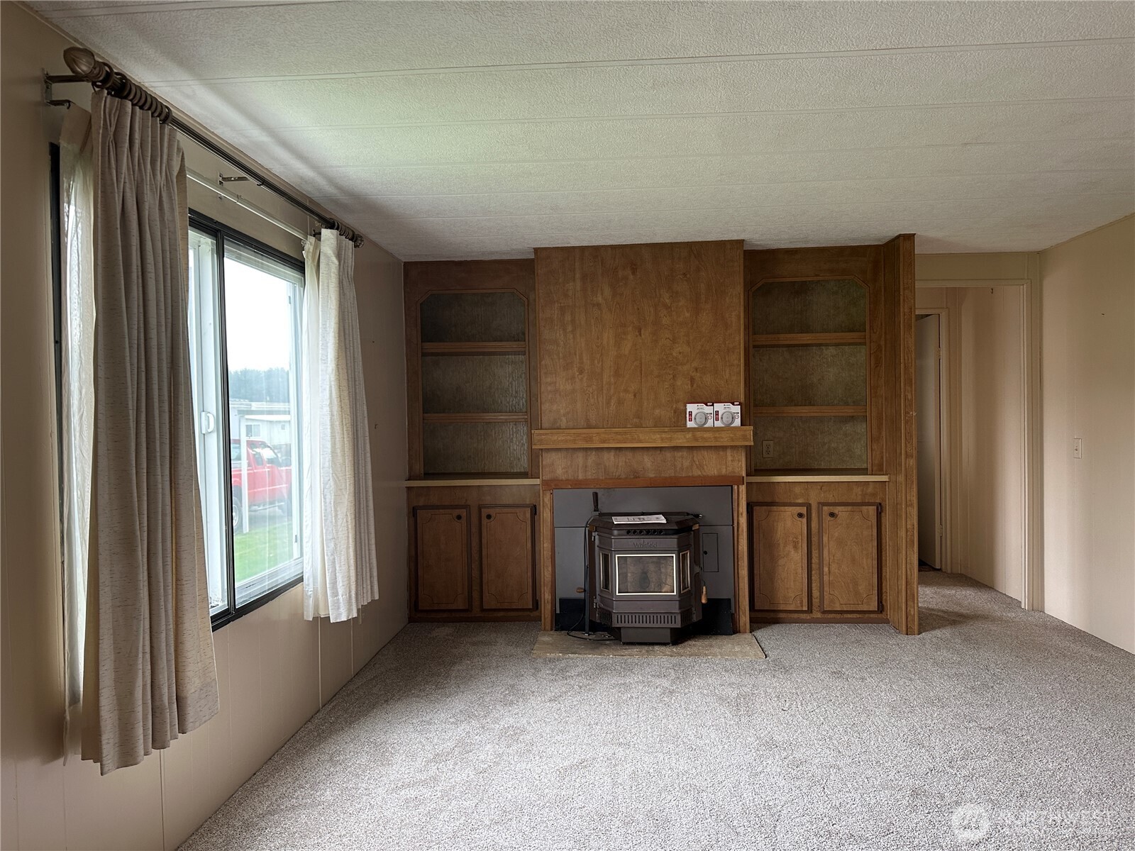 57 Clemons Road, Unit 49 Montesano, WA 98563 - Photo 10 of 23 a view of an empty room with a fireplace and a window
