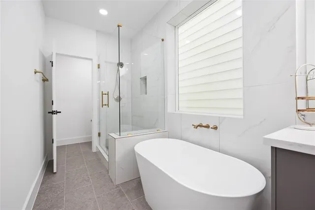 a large bathroom with a double vanity sink a mirror and a bathtub