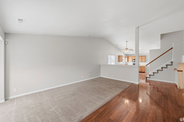 2575 Athena Drive Magna, UT 84044 - Photo 3 of 23 Spacious room featuring vaulted ceilings, light gray wall paint, and a combination of wood-finish flooring and carpeting
