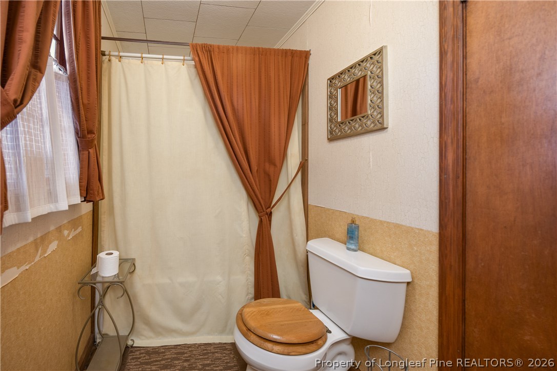 6346 Dunn Road Roseboro, NC 28382 - Photo 25 of 39 a white toilet sitting next to a shower curtain