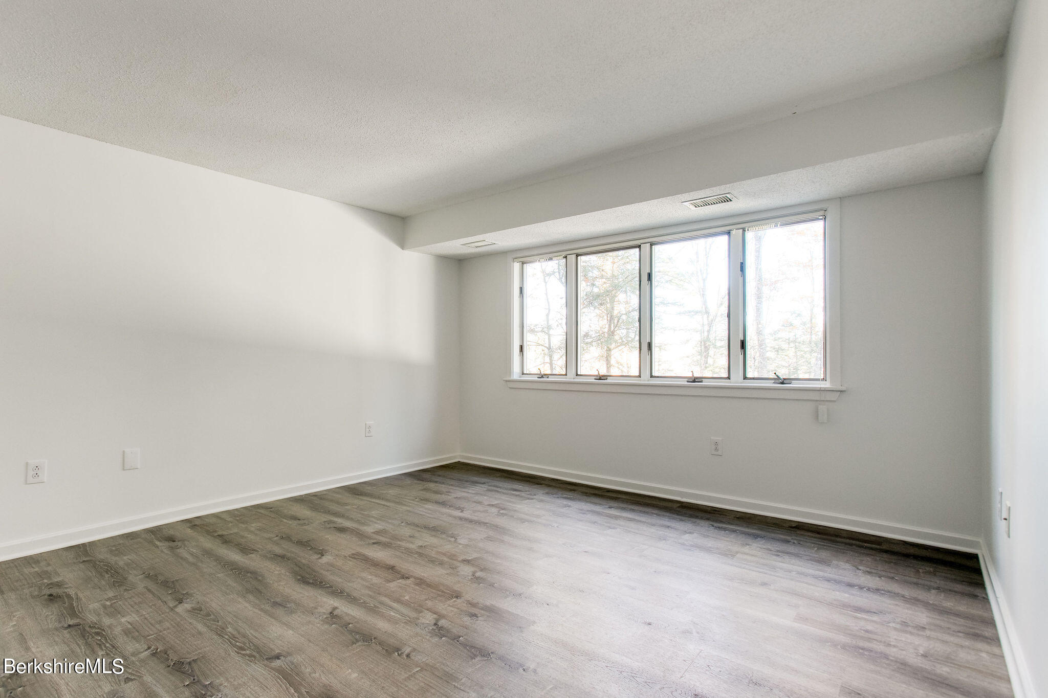 770 Summer Street, Unit 13B Lee, MA 01240 - Photo 29 of 39 a view of an empty room with wooden floor and a window