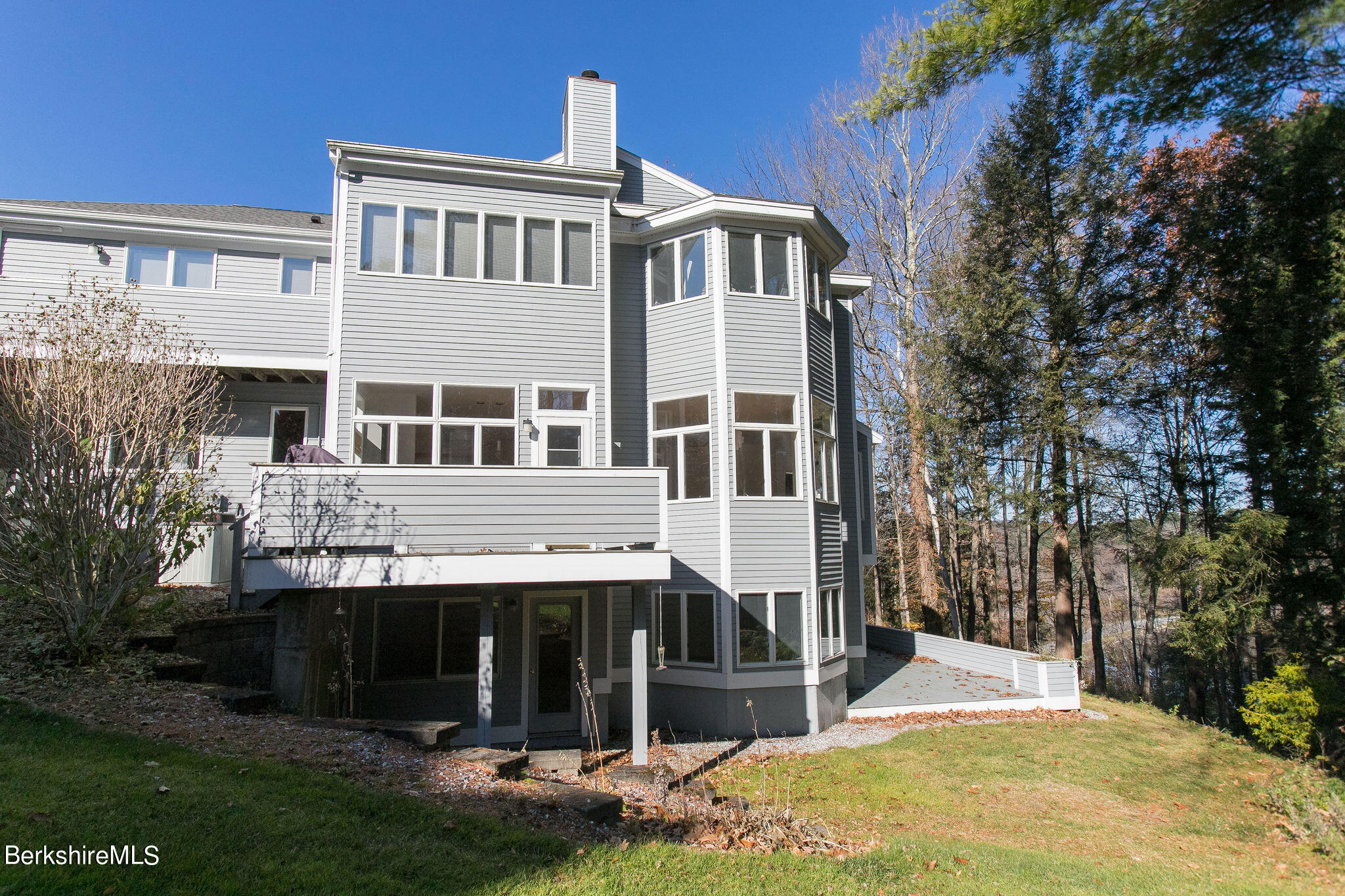 770 Summer Street, Unit 13B Lee, MA 01240 - Photo 35 of 39 a view of a white house with large windows and a yard