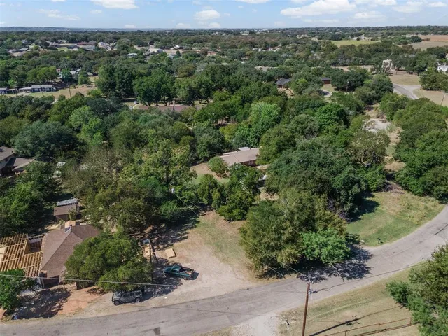 an aerial view of a houses with a yard and lake view