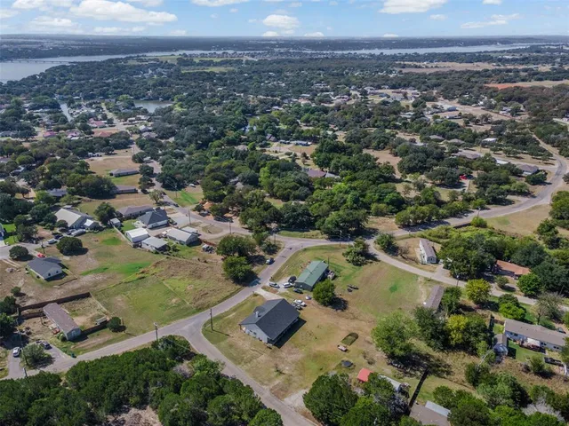 an aerial view of residential houses with outdoor space and trees
