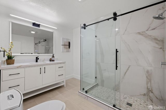 a spacious bathroom with a shower sink and mirror