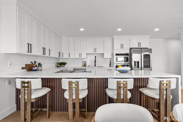a open dining room with stainless steel appliances granite countertop a dining table and chairs