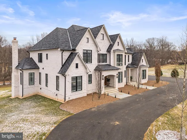 a dining room with wooden floor a chandelier a wooden table and chairs