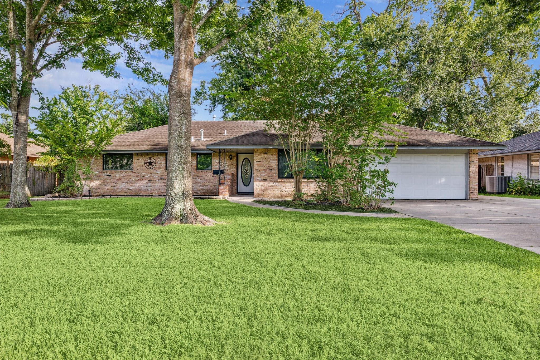 8907 Autauga Street Houston, TX 77080 - Photo 2 of 20 Charming single-story brick home mature trees, and a spacious driveway leading to a two-car garage.