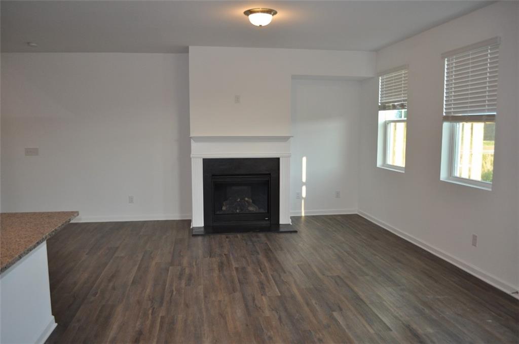 5745 Thornton Drive Cumming, GA 30028 - Photo 15 of 45 an empty room with wooden floor fireplace and windows
