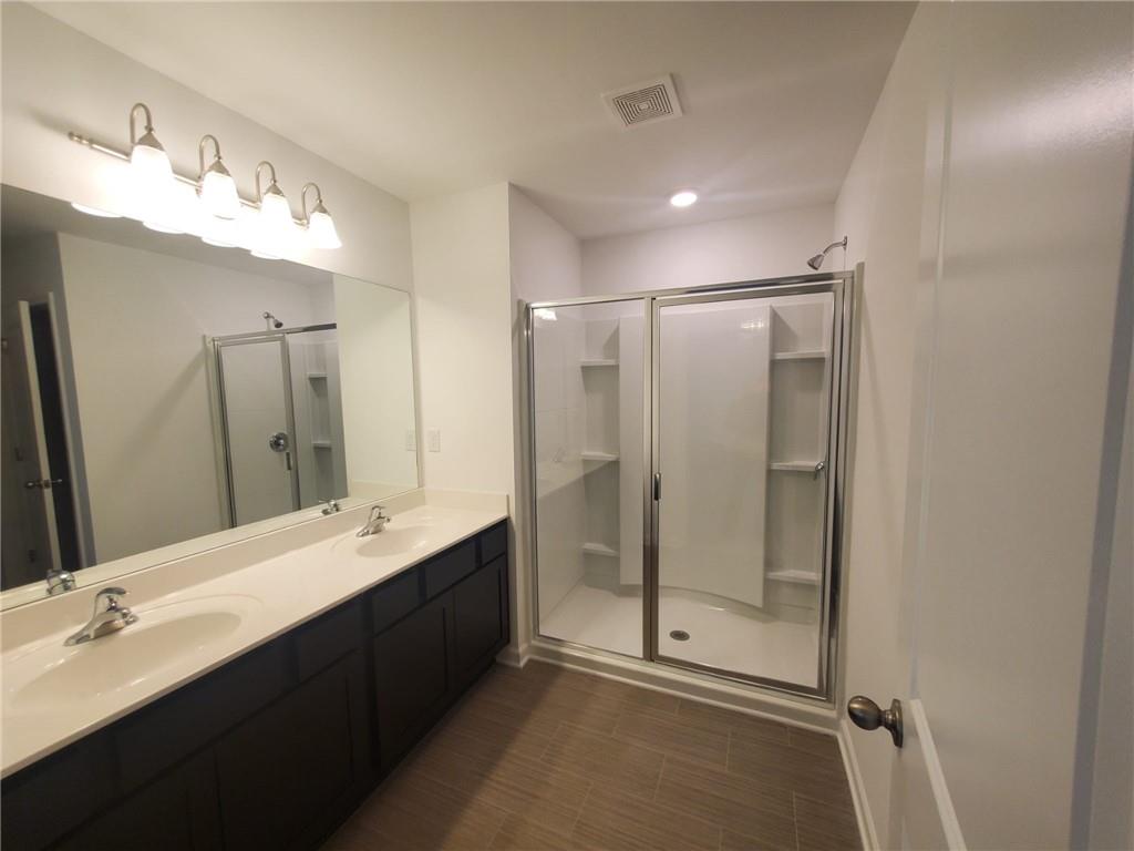 5745 Thornton Drive Cumming, GA 30028 - Photo 16 of 45 a bathroom with a double vanity sink mirror and shower