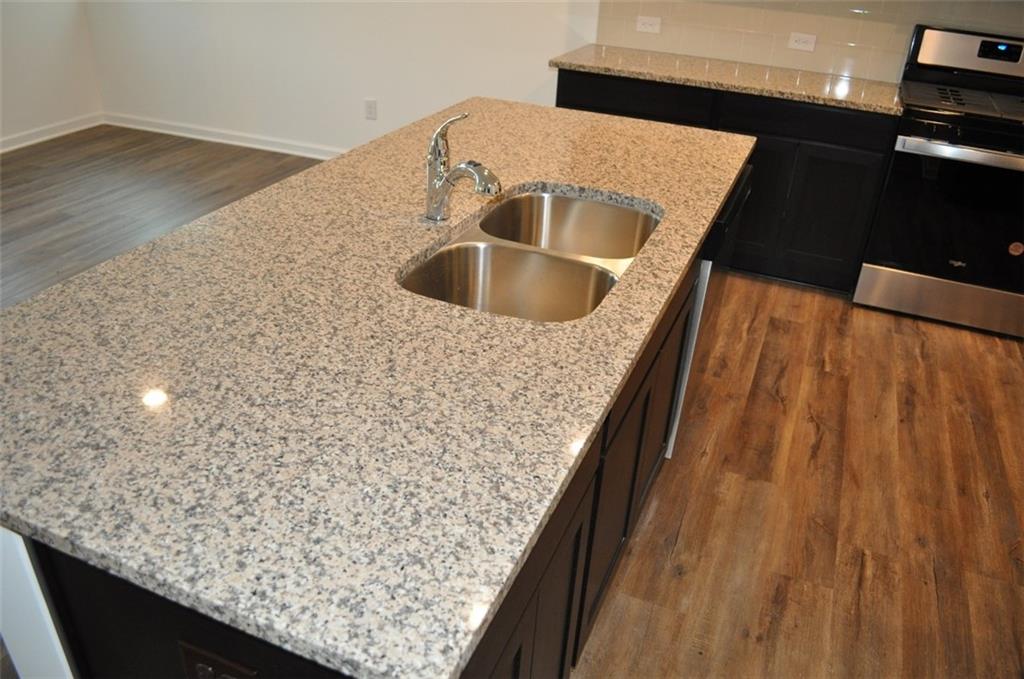 5745 Thornton Drive Cumming, GA 30028 - Photo 5 of 45 a kitchen with kitchen island a sink wooden floor and a counter top space
