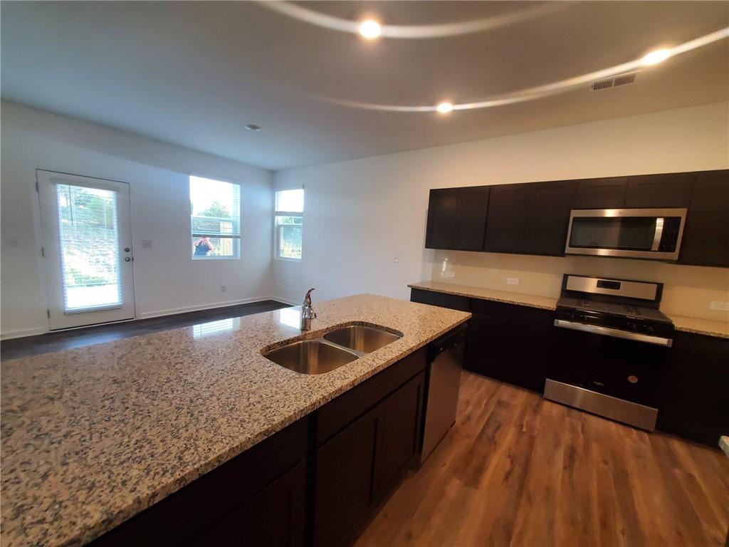 5745 Thornton Drive Cumming, GA 30028 - Photo 7 of 45 a kitchen with granite countertop a sink and a stove