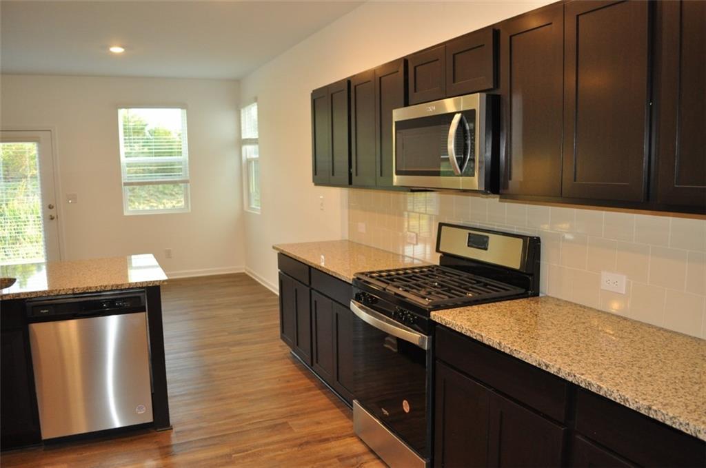 5745 Thornton Drive Cumming, GA 30028 - Photo 10 of 45 a kitchen with granite countertop a stove and a microwave