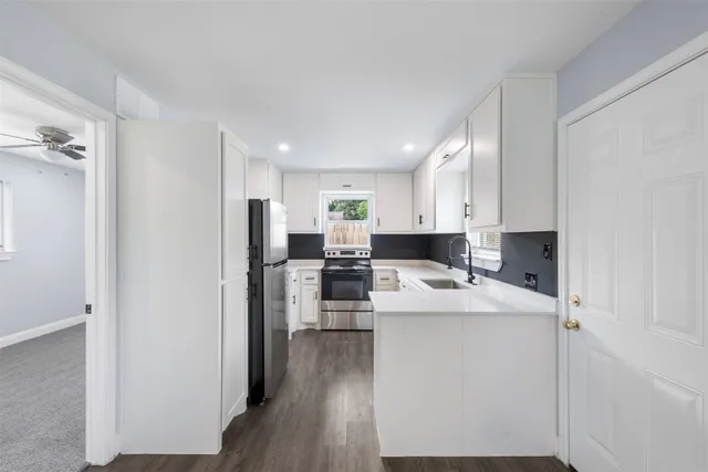 a kitchen with a sink cabinets and wooden floor