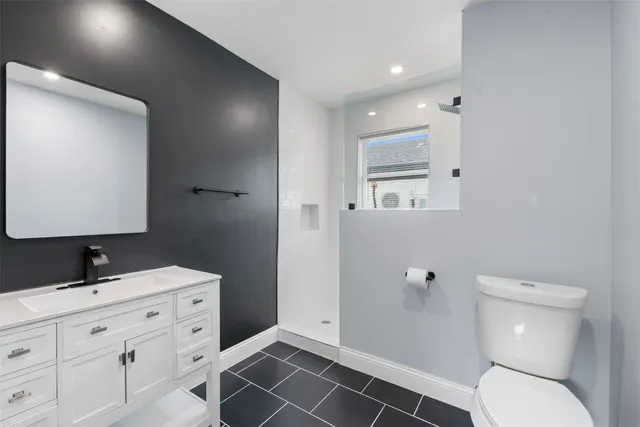 a bathroom with a toilet sink and mirror