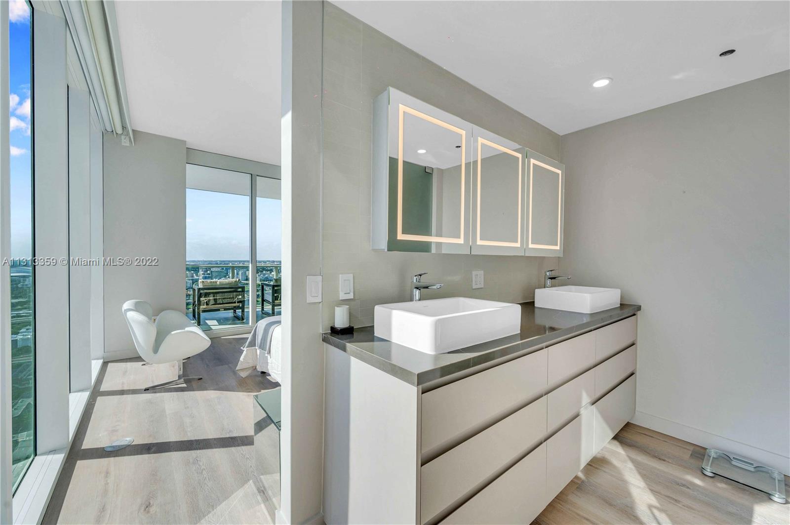 1040 Biscayne Boulevard, Unit PH4407 Miami, FL 33132 - Photo 46 of 74 a bathroom with a granite countertop sink and a mirror