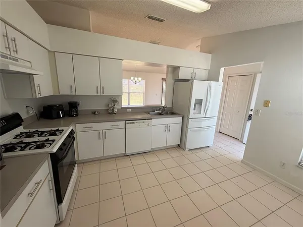 a kitchen with a sink a refrigerator and window