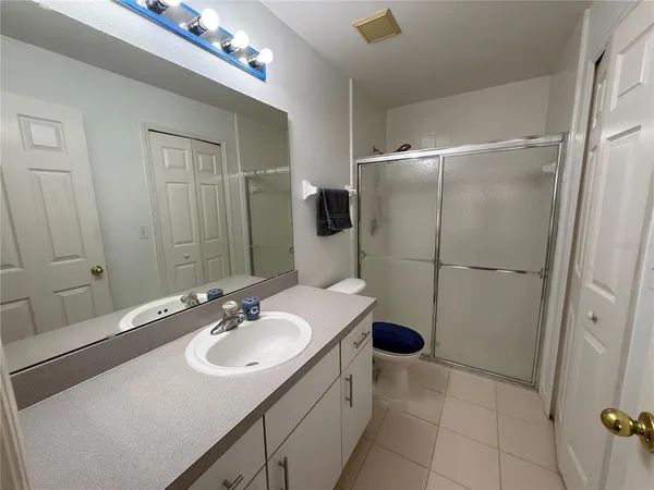 a bathroom with a sink shower and a mirror