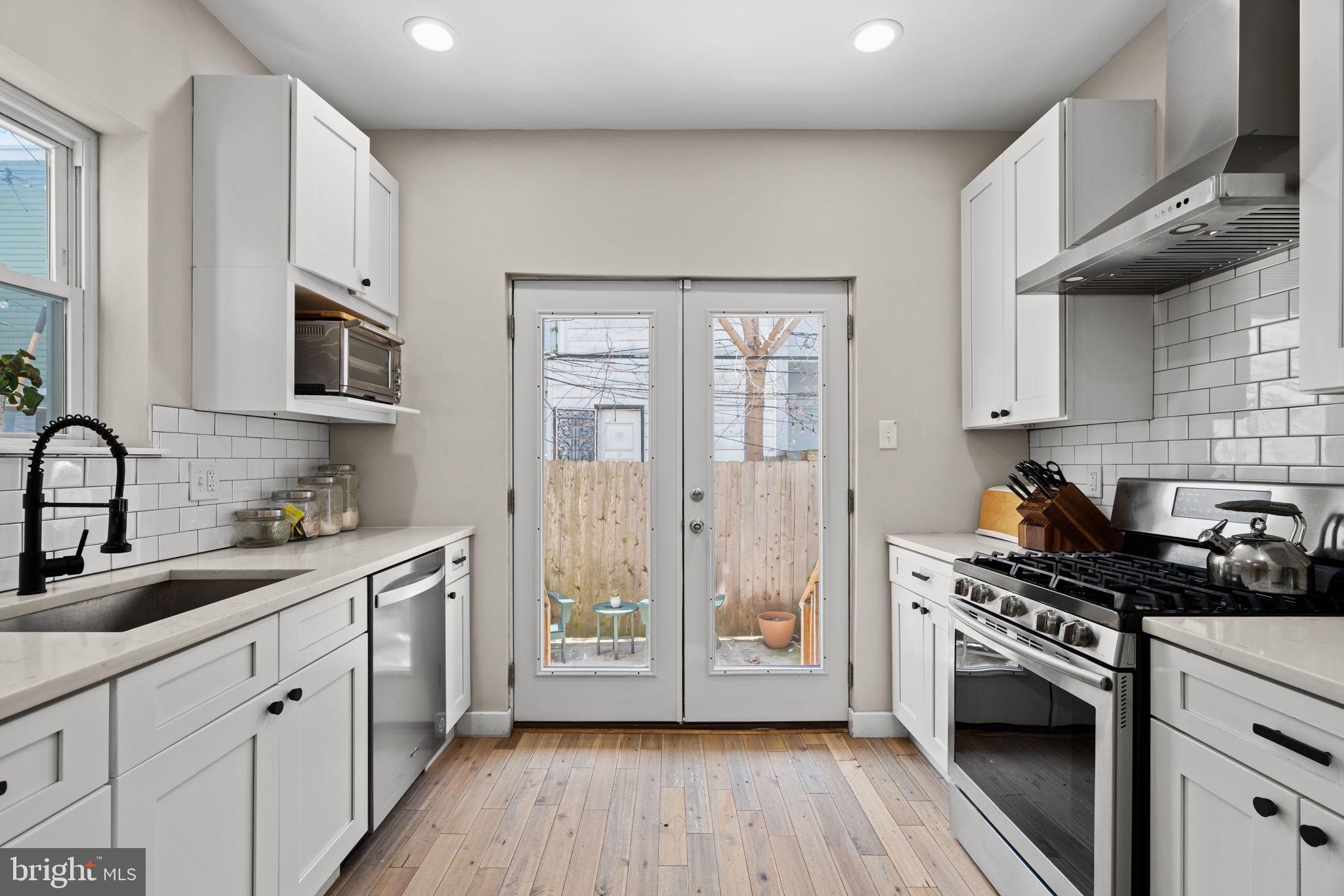 2934 Nicholas Street Philadelphia, PA 19121 - Photo 11 of 33 a kitchen with stainless steel appliances a stove sink and cabinets