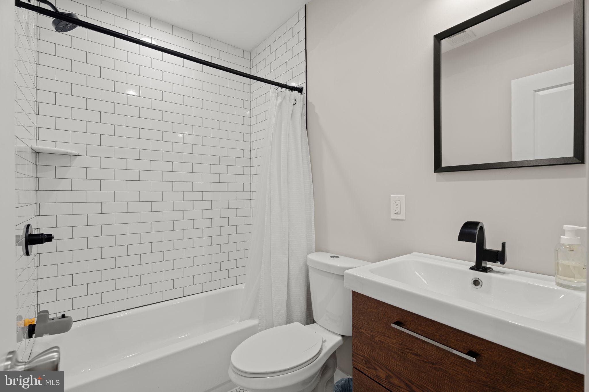 2934 Nicholas Street Philadelphia, PA 19121 - Photo 20 of 33 a bathroom with a bathtub shower sink vanity and toilet