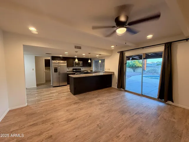 a large kitchen with stainless steel appliances granite countertop a refrigerator and a stove top oven