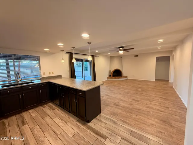 a kitchen with a sink and wooden floor