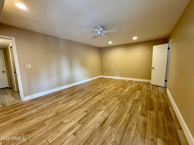 a view of a big room with wooden floor and a ceiling fan