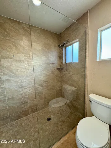 a bathroom with a toilet and a shower