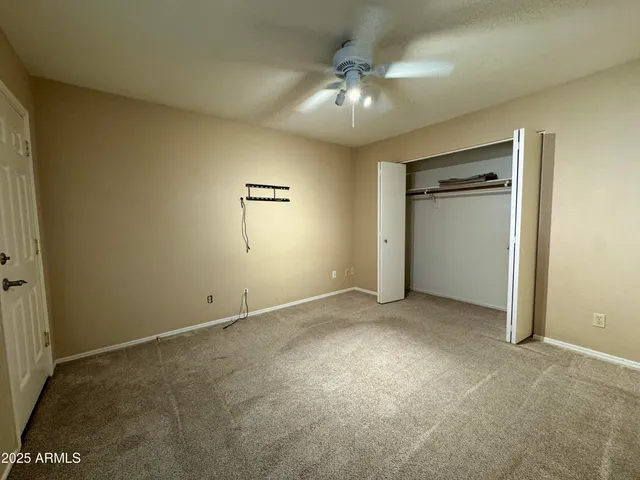 an empty room with chandelier fan