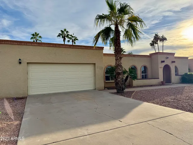 a view of a house with a yard and potted plants