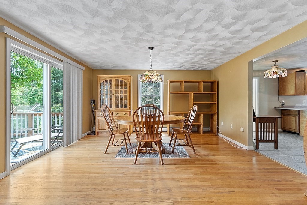 54 Little Turnpike Road Shirley, MA 01464 - Photo 15 of 39 a dining room with furniture a chandelier and wooden floor