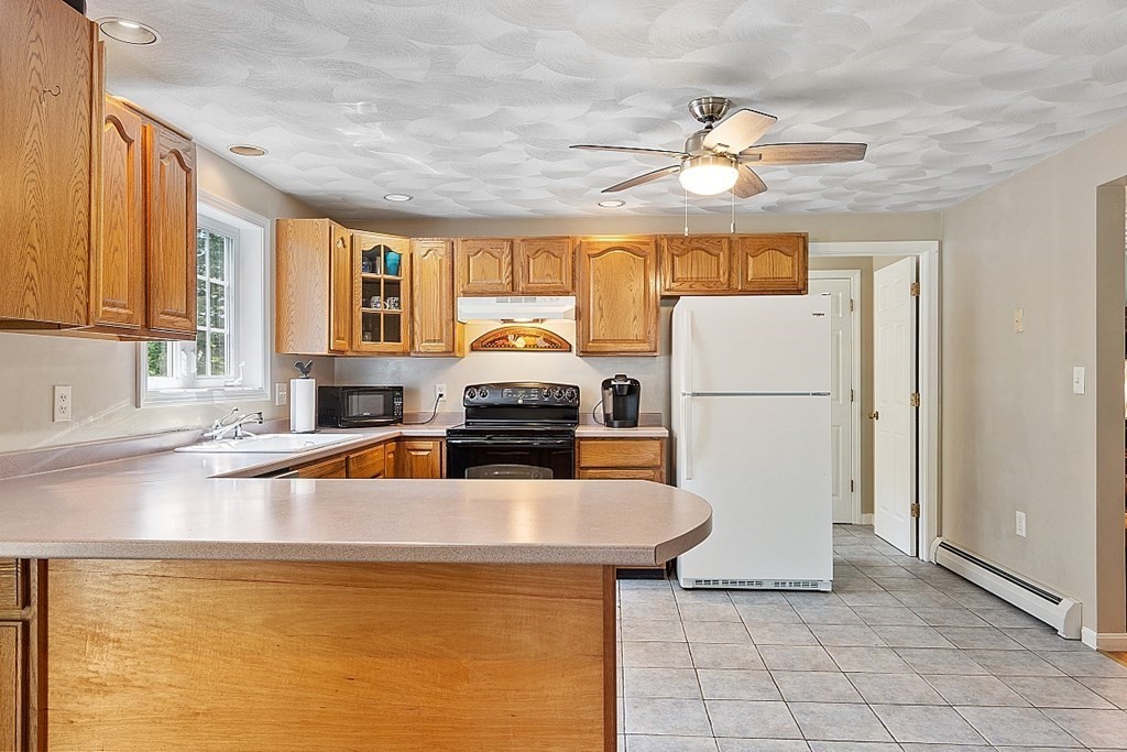 54 Little Turnpike Road Shirley, MA 01464 - Photo 5 of 39 a kitchen with refrigerator a stove a sink and a cabinets
