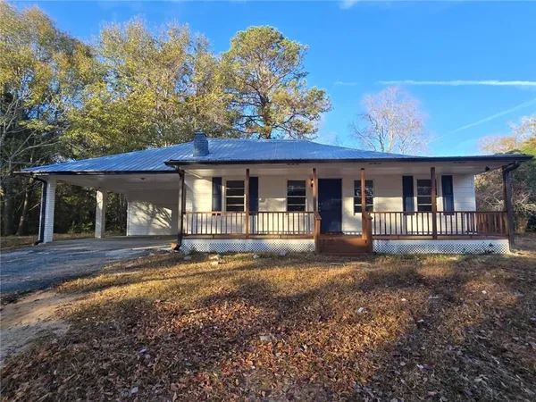 a view of a house with a small yard and large tree