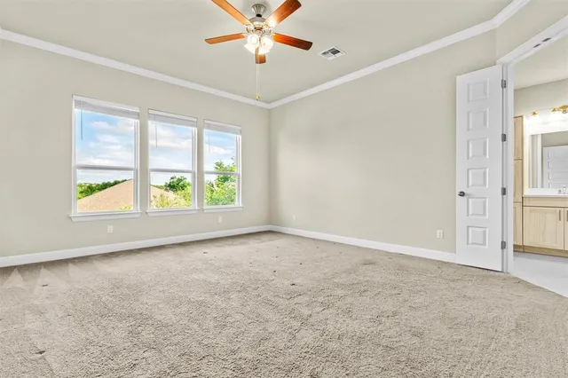 an empty room with fan and windows