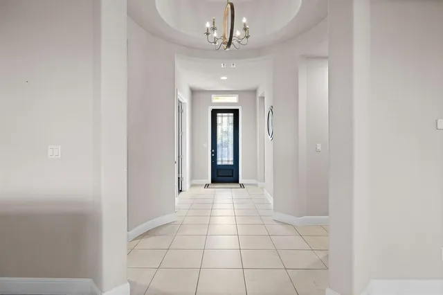 a view of a hallway with a chandelier fan and windows