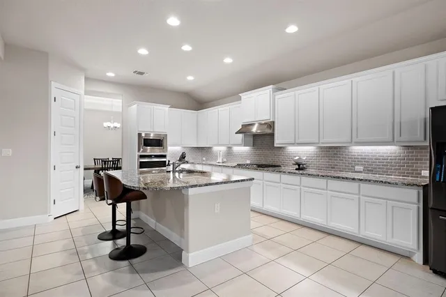a kitchen with cabinets and chairs