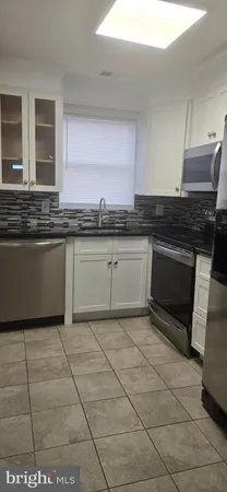 a kitchen with granite countertop a stove a sink and a granite counter tops