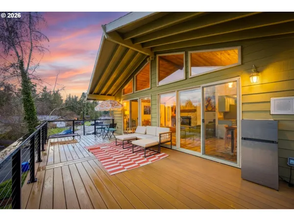 a balcony with wooden floor and outdoor seating