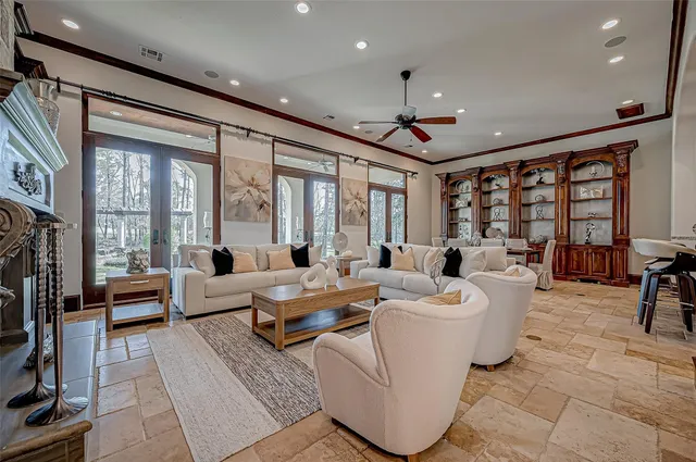 a living room with fireplace furniture and a large window