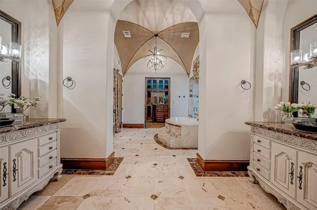 a bathroom with a granite countertop sink a potted plant and a window