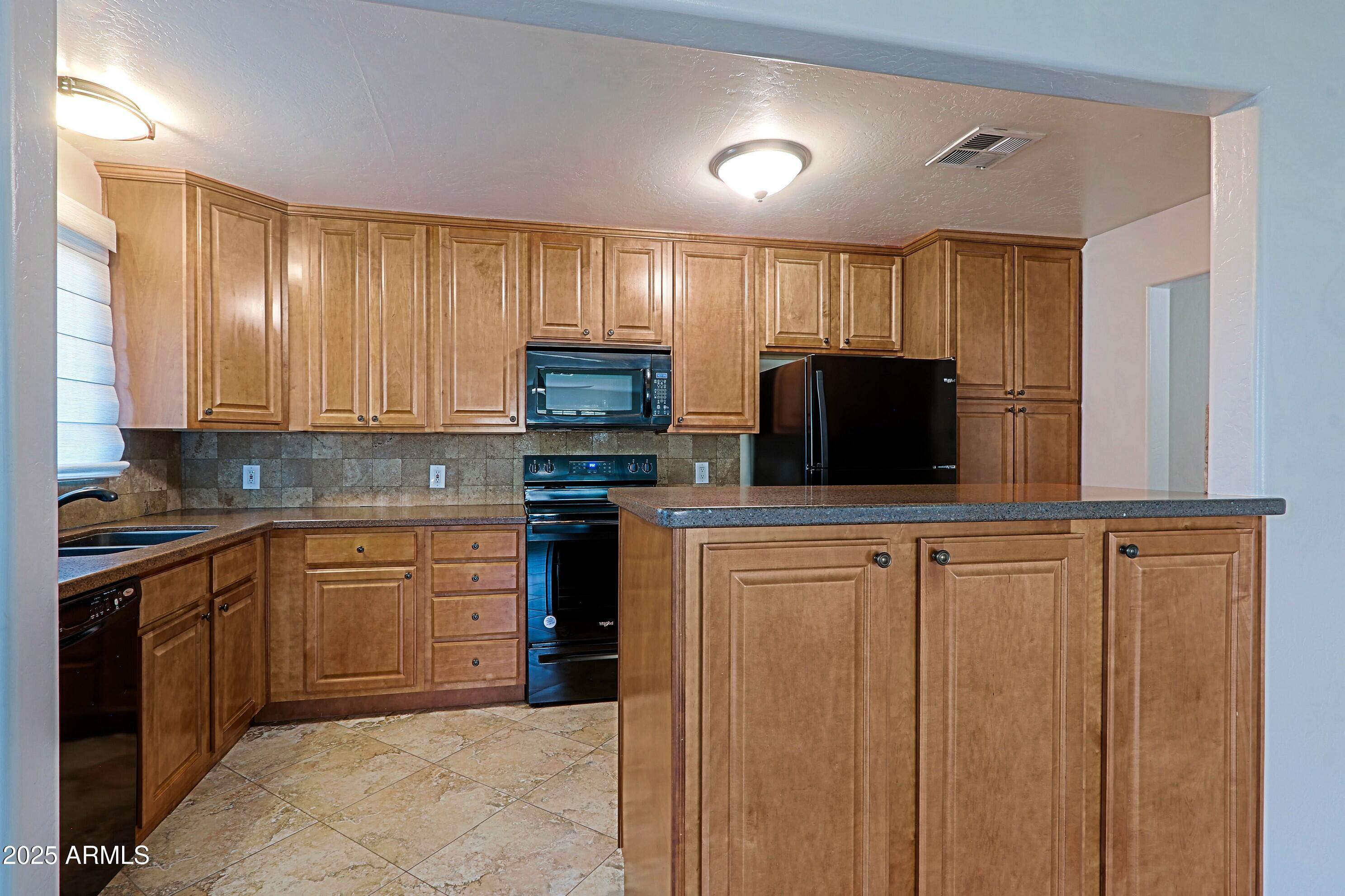 5509 East Cheery Lynn Road, Unit 2E Phoenix, AZ 85018 - Photo 11 of 25 a kitchen with stainless steel appliances a refrigerator sink and microwave