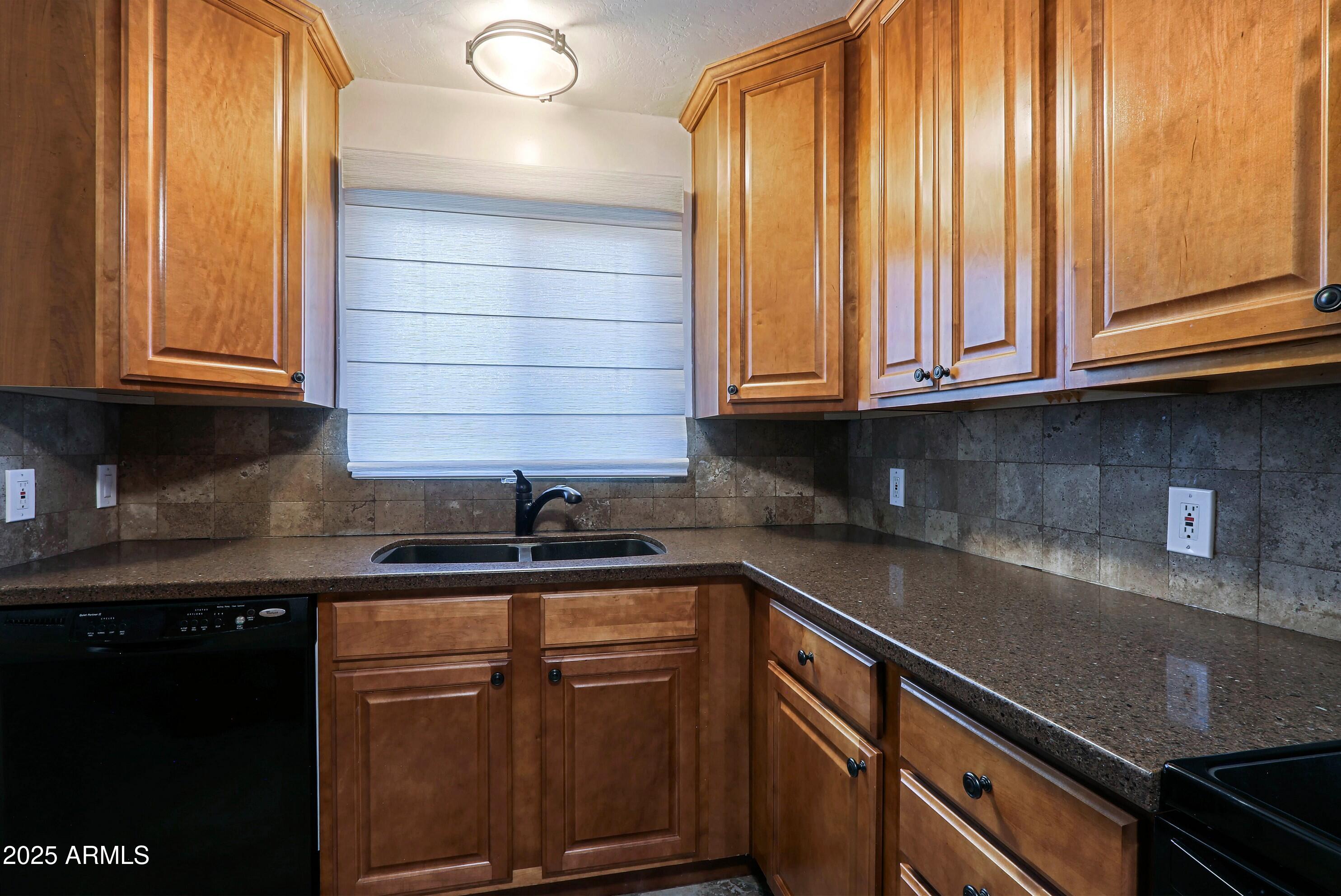 5509 East Cheery Lynn Road, Unit 2E Phoenix, AZ 85018 - Photo 14 of 25 a kitchen with granite countertop stainless steel appliances a sink window and cabinets
