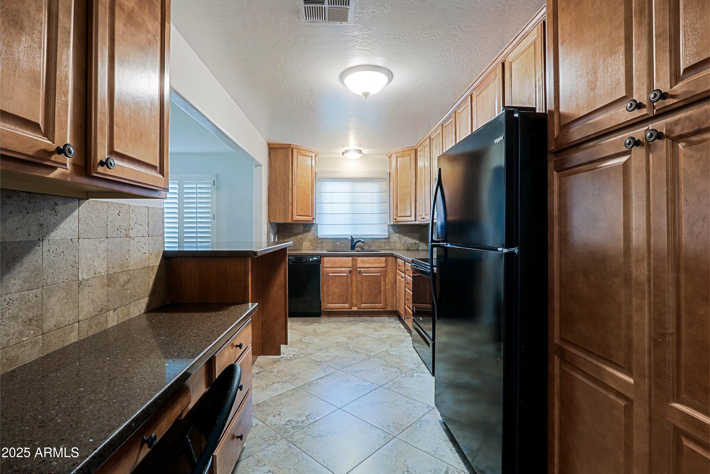 5509 East Cheery Lynn Road, Unit 2E Phoenix, AZ 85018 - Photo 15 of 25 a kitchen with granite countertop a refrigerator and a stove