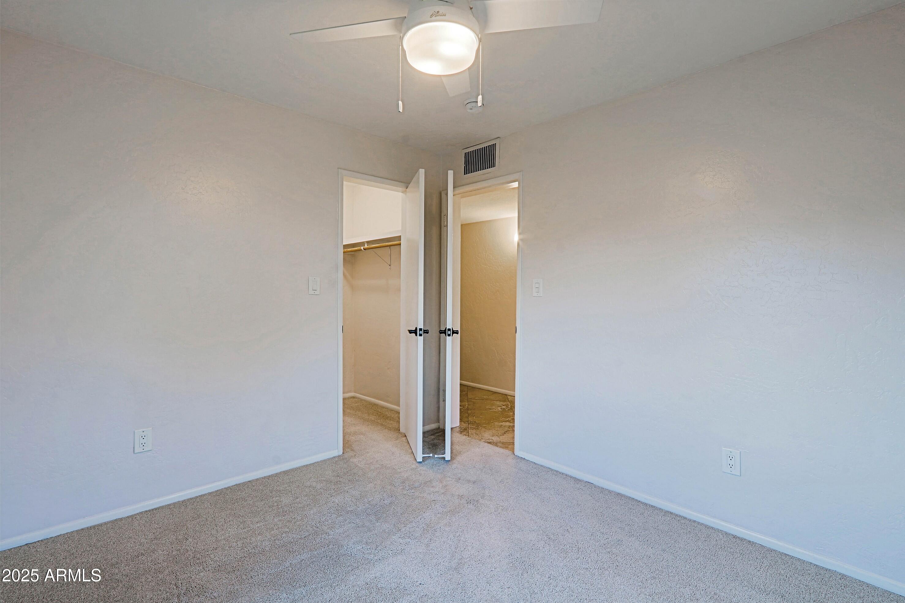 5509 East Cheery Lynn Road, Unit 2E Phoenix, AZ 85018 - Photo 19 of 25 an empty room with closet and wooden floor