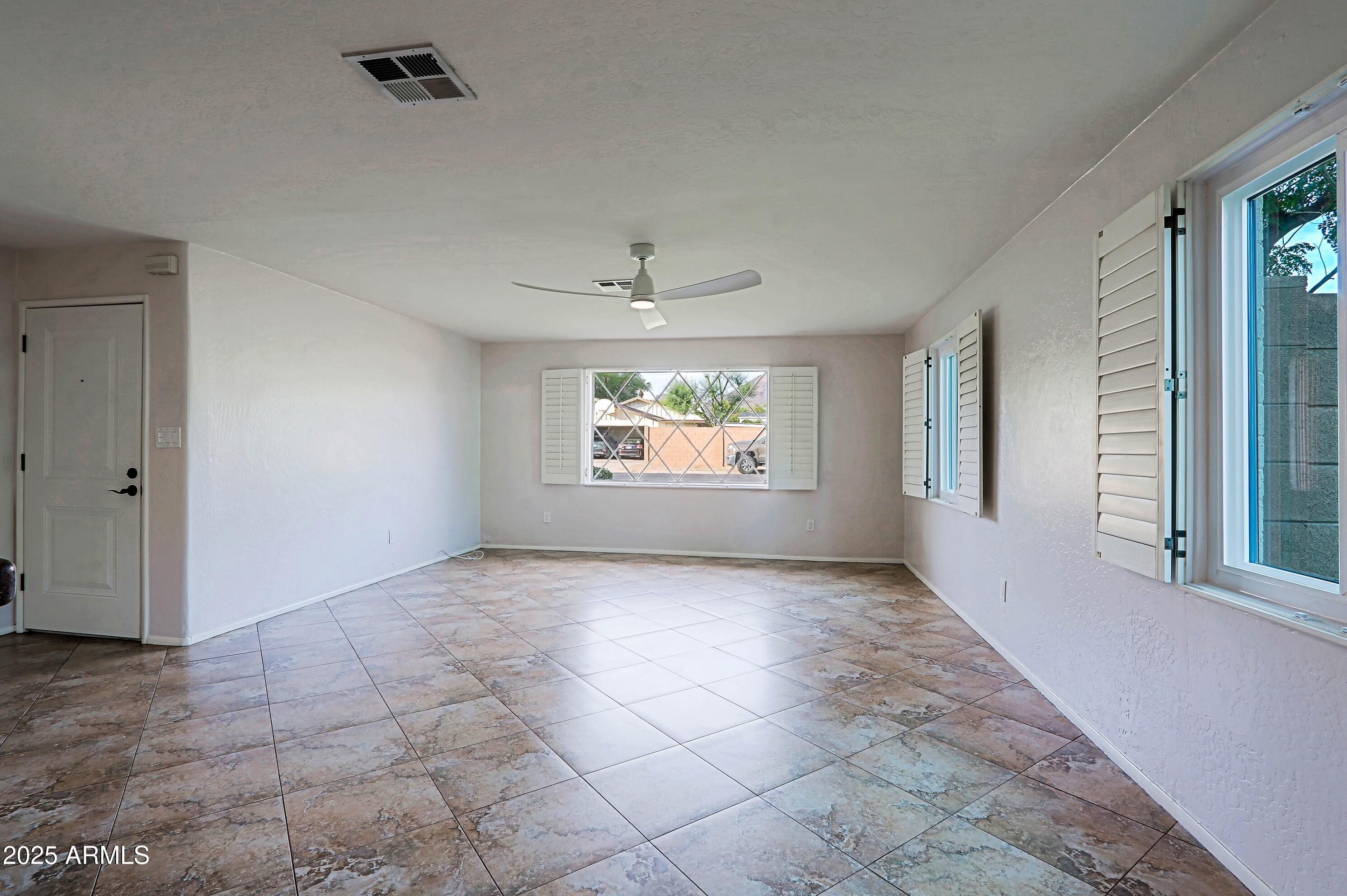 5509 East Cheery Lynn Road, Unit 2E Phoenix, AZ 85018 - Photo 6 of 25 an empty room with windows and closet