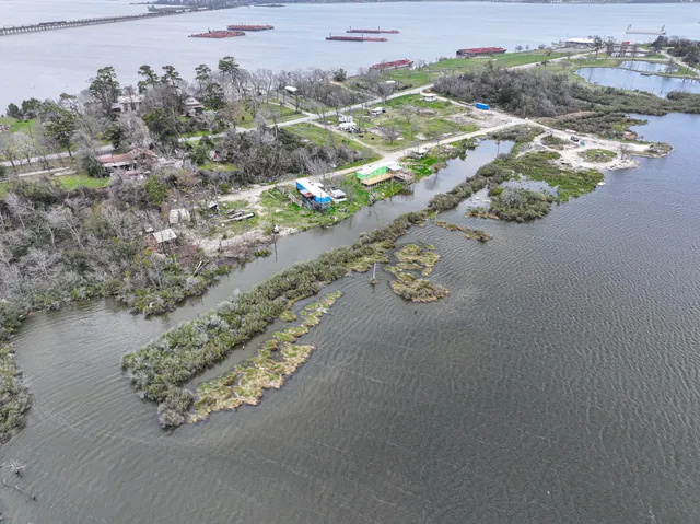 an aerial view of a house with a yard and lake view