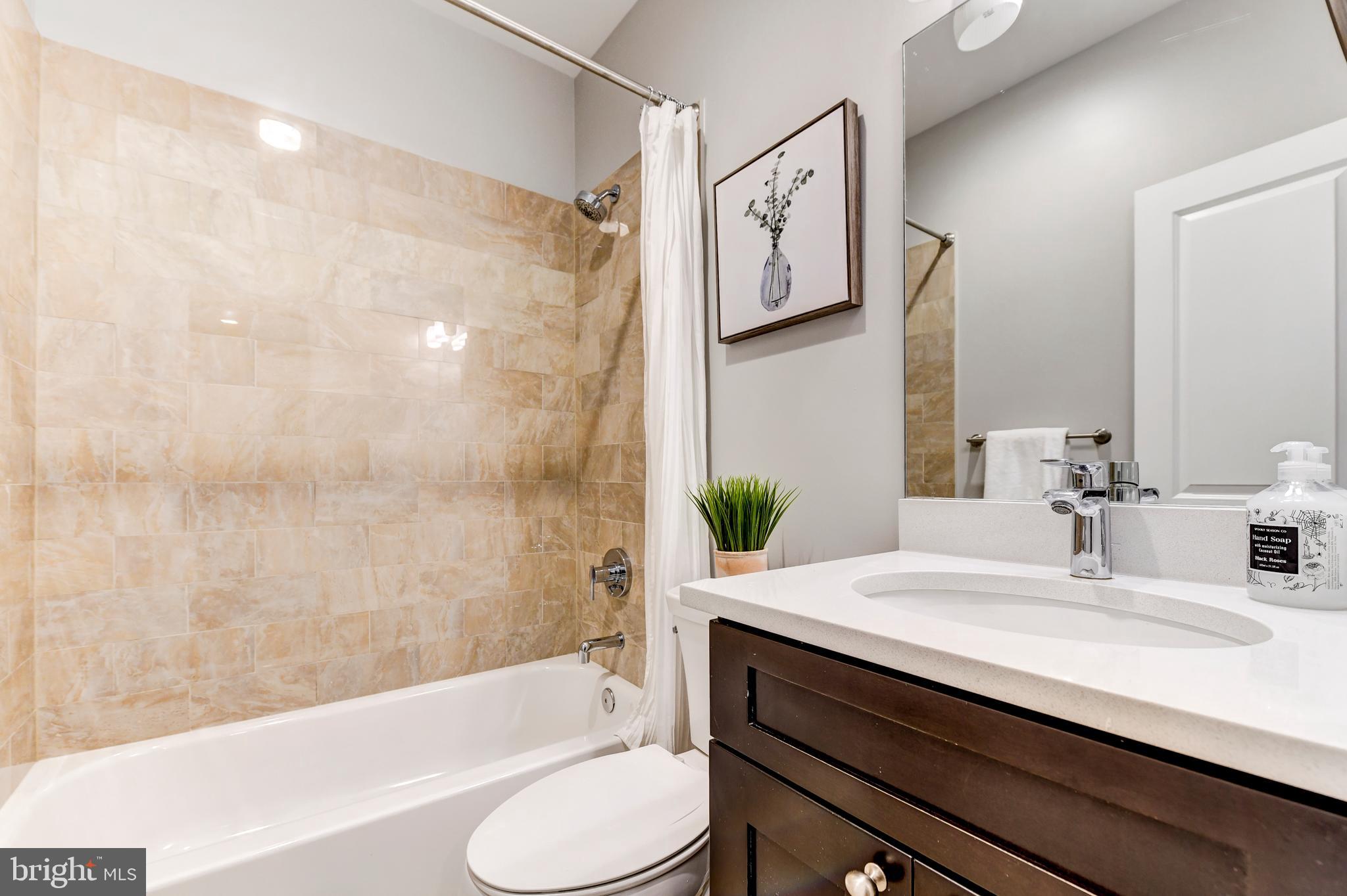 1928 3rd Street Northeast, Unit 2 Washington, DC 20002 - Photo 13 of 20 a bathroom with a sink a toilet and bathtub